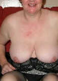 Eine Rentnerin zeigt ihre schlaffen Brüste